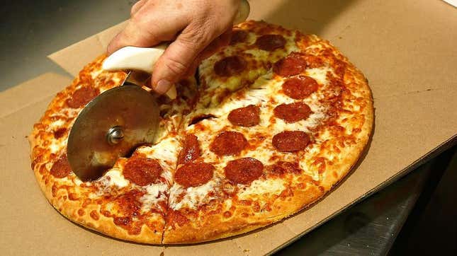 hand slicing little caesars pizza