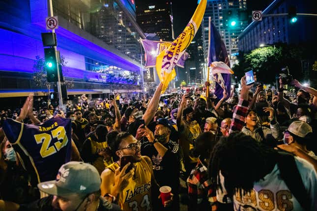 Lakers fans celebrate in front of the Staples Center on October 11, 2020 in Los Angeles, California. People gathered to celebrate after the Los Angeles Lakers defeated the Miami Heat in game 6 of the NBA finals.
