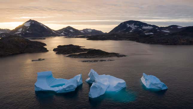 icebergs float away as the sun rises near Kulusuk, Greenland.