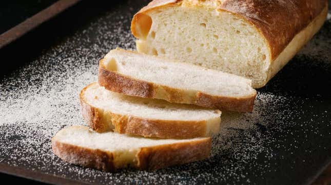 Sliced white bread on floured surface