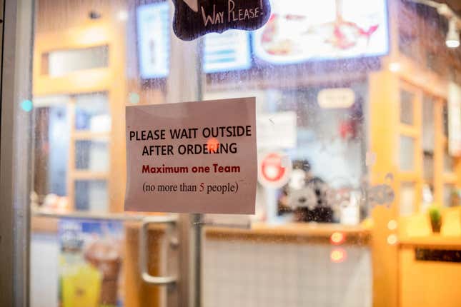 restaurant sign asking patrons to wait outside for pickup