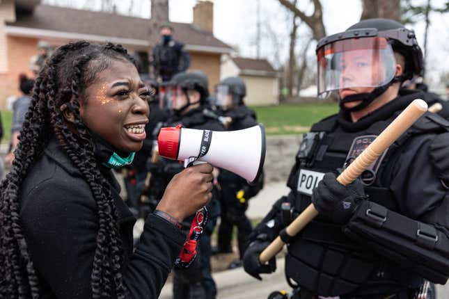 A woman confronts police officers standing in line as protesters gather after an officer shot and killed a black man in Brooklyn Center, Minneapolis, Minnesota on April 11,2021. 