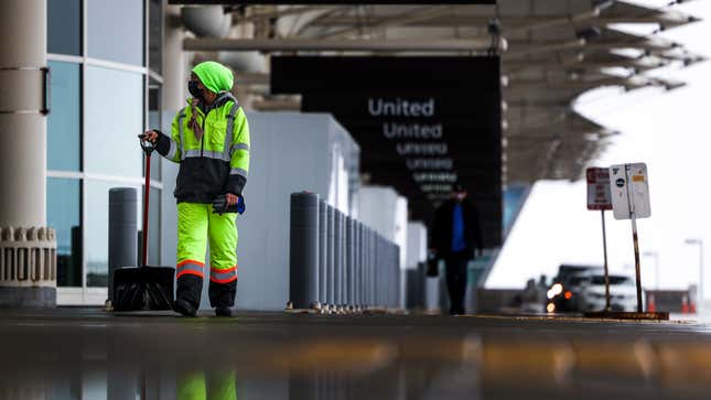  A Denver International Airport employee walks with a shovel in the passenger drop-off area on March 13, 2021 in Denver, Colorado. 