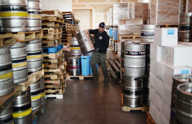 Delivery man stacks kegs of beer