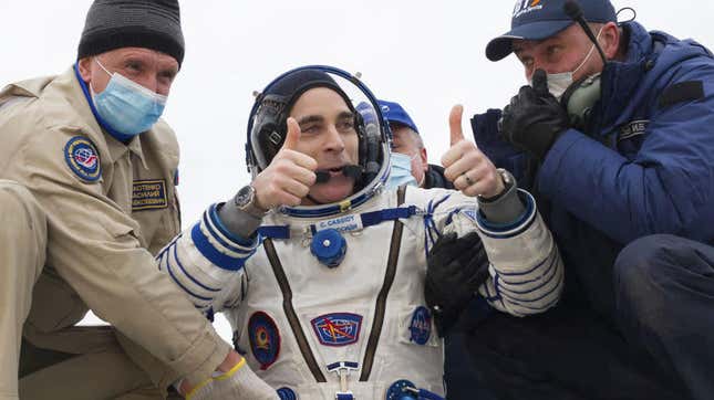 NASA astronaut Christopher Cassidy (C) thumbs up as he leaves the Soyuz MS-16 reentry capsule
