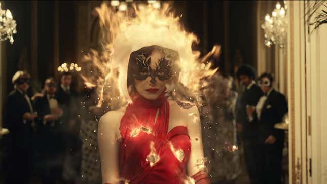 A screenshot from DIsney's Cruella of Cruella's white dress burning up to reveal a red one