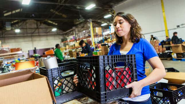 Young woman volunteering to organize donations in large food bank