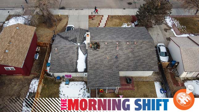 In this aerial view from a drone, people walk past a home with a hole in the roof from falling debris from an airplane engine on February 20, 2021 in Broomfield, Colorado. An engine on the Boeing 777 exploded after takeoff from Denver prompting the flight to return to Denver International Airport where it landed safely.