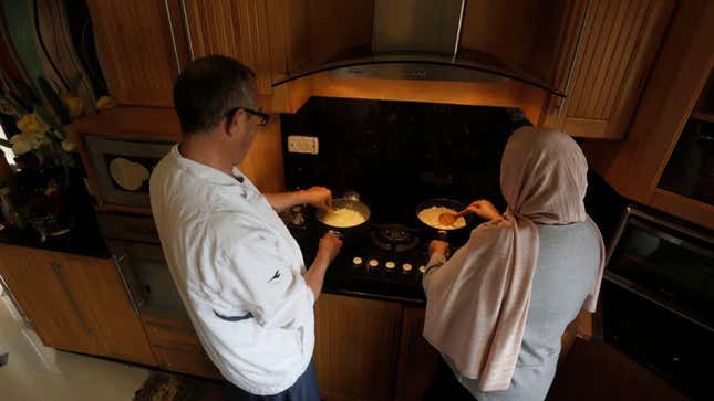 two people cooking over home stove