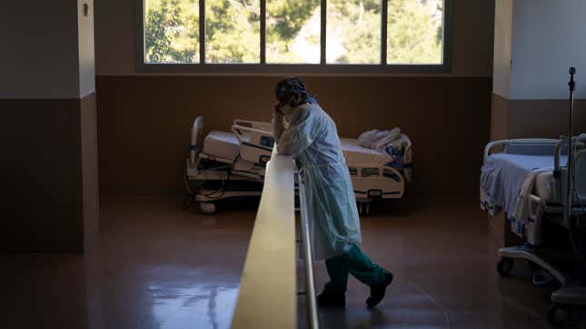 Respiratory therapist Babu Paramban talks on the phone next to hospital beds while taking a break in the COVID-19 unit at Providence Holy Cross Medical Center in the Mission Hills section of Los Angeles, Thursday, Nov. 19, 2020.
