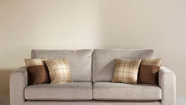 Image for article titled Empty Wall Behind Couch Falls Into Girlfriend’s Crosshairs