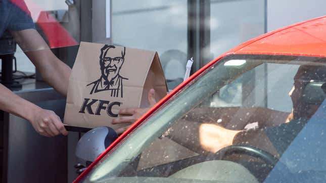 KFC worker hands bag of food to drive-thru customer