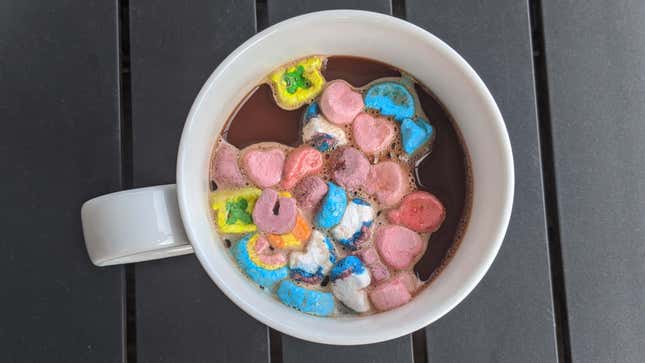 White mug of hot chocolate with partially dissolved cereal marshmallows on top