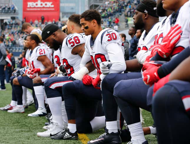 Members of the Houston Texans, including Kevin Johnson #30 and Lamarr Houston #58, kneel during the national anthem before the game at CenturyLink Field on October 29, 2017 in Seattle, Washington. 
