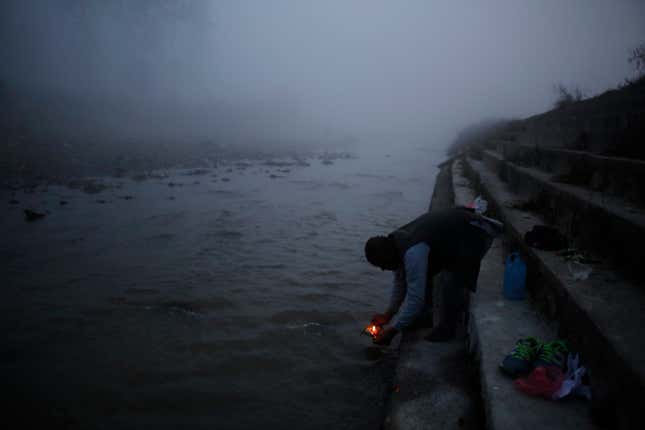 A devotee lights an oil lamp during the Gaya Aunsi festival in Kathmandu, Nepal, on Monday, Dec. 18, 2017.