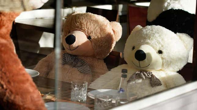 Giant teddy bears seated at restaurant table