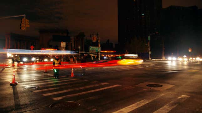 An NYPD traffic cop works the giant intersection ahead of the Manhattan Bridge during the Sandy blackout.