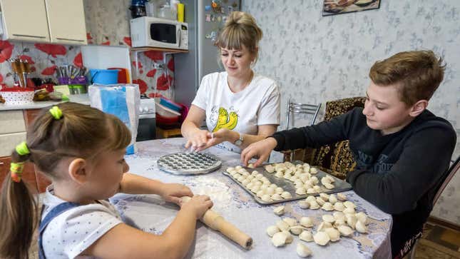 family making dumplings in kitchen