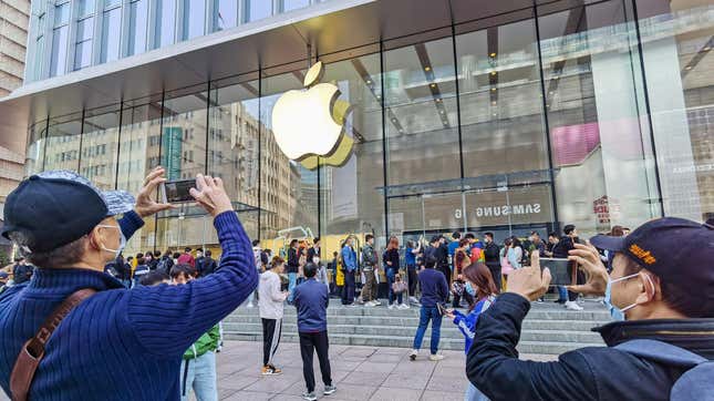 Customers queue to get their reserved iPhone 12 mobile phones at an Apple store in Shanghai on Oct. 23, 2020.