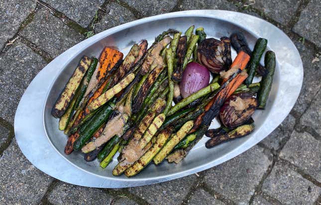 Metal pan full of Roasted Vegetables with Balsamic "Benihana" Garlic Sauce on stone surface