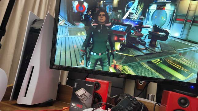 a photo of the playstation 5 next to a television screen showing marvel's avengers