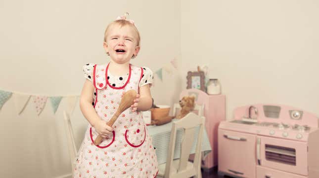 Little girl in apron crying