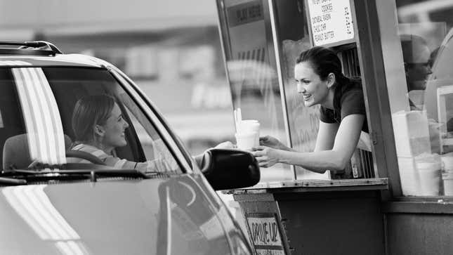 Customer being handed an order at the drive-thru window by an employee