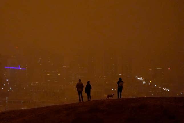 People look toward the skyline obscured by wildfire smoke in daytime from Kite Hill Open Space in San Francisco, Wednesday, Sept. 9, 2020.