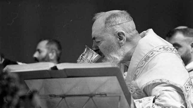 Black-and-white photo of Catholic priest drinking the Sacramental wine