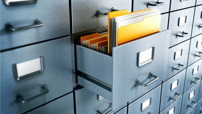 A filing cabinet with an open drawer containing manila envelopes full of paper