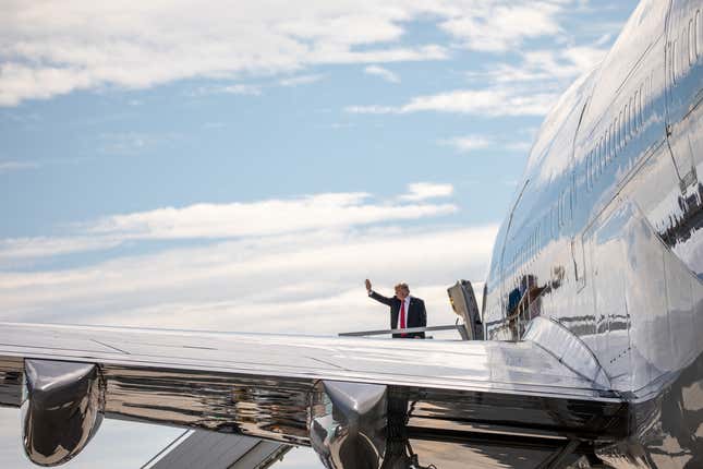 President Trump waves from the door of Air Force One.