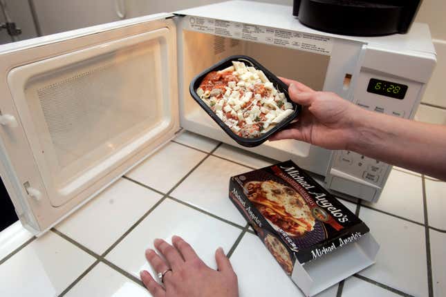Abi Jones, of HeatEatReview.com, places a frozen food item for dinner and review into her microwave oven at her home in Palo Alto, Calif., Wednesday, March 5, 2008.