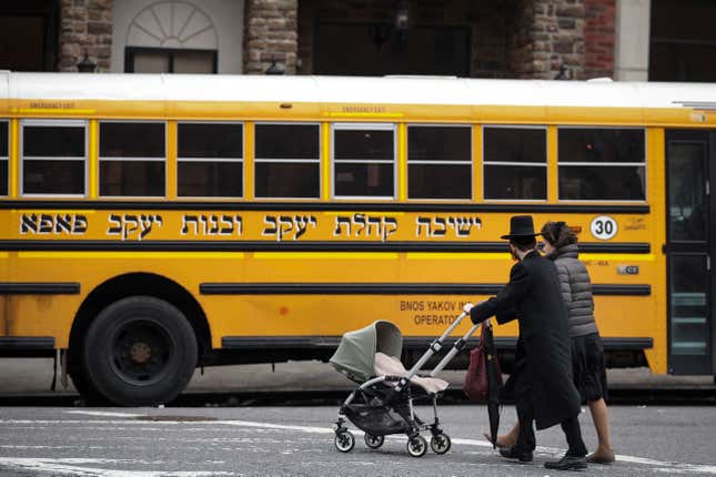  A couple pushing strollers walk past the Yeshiva Kehilath Yakov School South Williamsburg. 