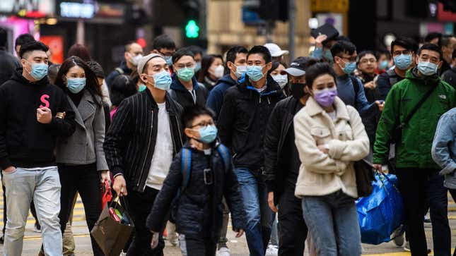 Pedestrians wearing face masks near a Lunar New Year celebration in Hong Kong on Jan. 27, 2020.