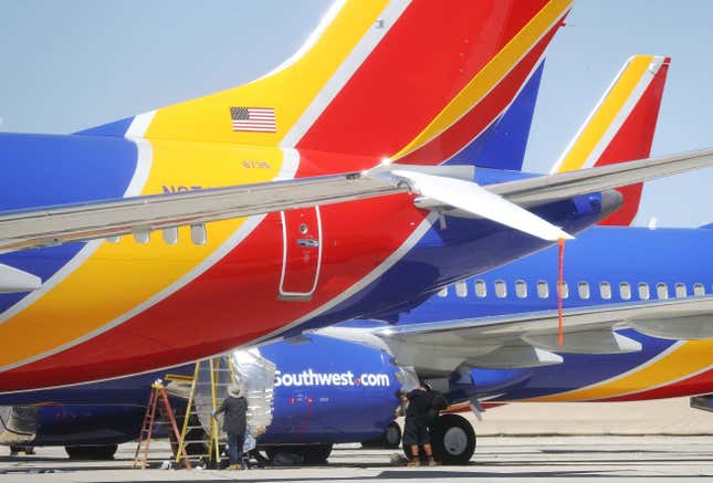 Workers stand beneath Southwest Airlines Boeing 737 MAX aircraft parked at Southern California Logistics Airport on March 27, 2019 in Victorville, California.