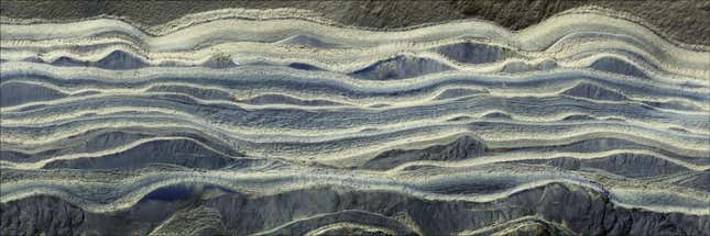 This composite image shows alternating layers of ice and sand in an area where they’re exposed on the surface of Mars. The water ice appears as light-colored, while the sand is darker blue.