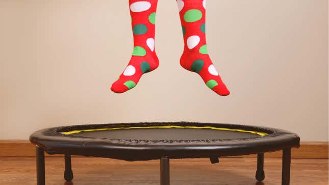 Feet jumping on small trampoline with funny holiday socks