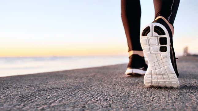 Feet in running shoes on a beach or something