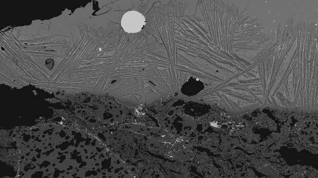 Microscopic image showing a rounded steel fragment trapped in slag.