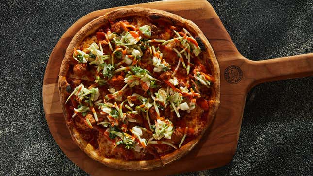 Hot chicken pizza on a wooden cutting board