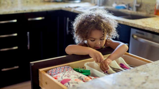 Child rummaging through kitchen drawer