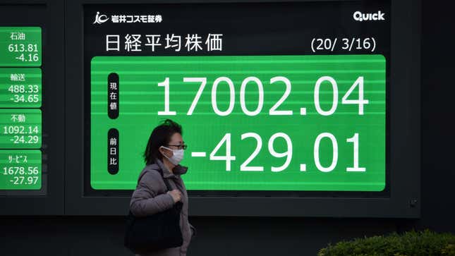 File photo of a woman passing a quotation board displaying share price closing numbers of the Tokyo Stock Exchange in Tokyo.