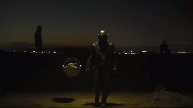 Screenshot from The Mandalorian featuring the titular armord warrior standing near Baby Yoda floating in a pod and surrounded by menacing figures.