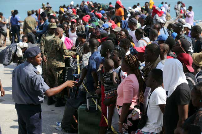 A Bahama’s Army officer speaks with people evacuated prior boarding a ferry to Nassau at the Port in Marsh Harbor, Abaco Island, Bahamas, Saturday, Sept. 7, 2019. 