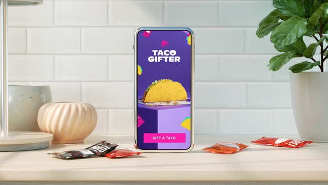 The Taco Bell app's Taco Gifter, displayed on phone screen on a countertop with hot sauce packets