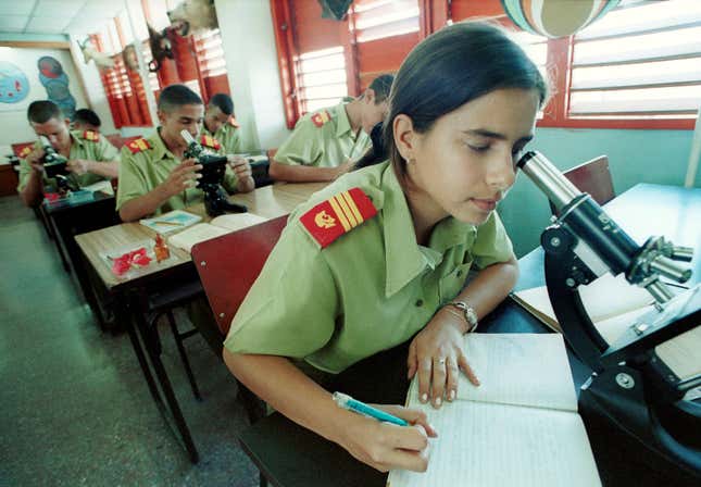 Yumara Borges, 15, and other students look through microscopes as they study at a laboratory November 26, 2001 at the School of the Army ‘Camilo Cienfuegos’ near Havana, Cuba.