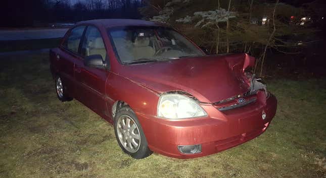 Image for article titled You Haven't Reached Rock Bottom Until You've Got A Totaled Kia Rio Stuck In Your Backyard