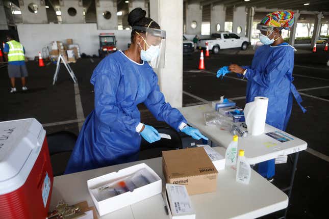Registered nurses Gina Aubourg (L) and Renee Lewis begin testing at the COVID-19 drive-thru testing site at the Duke Energy for the Arts Mahaffey Theater on July 8, 2020, in St. Petersburg, Fla. 