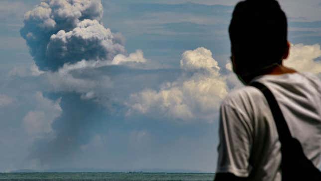 A man watches the Anak Krakatau volcano in Indonesia erupt on Saturday.