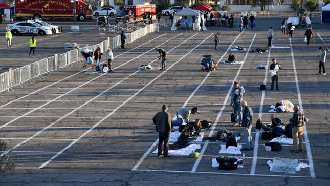 People arrive at a temporary homeless shelter with painted social-distancing boxes in a parking lot at Cashman Center on March 30, 2020 in Las Vegas, Nevada.